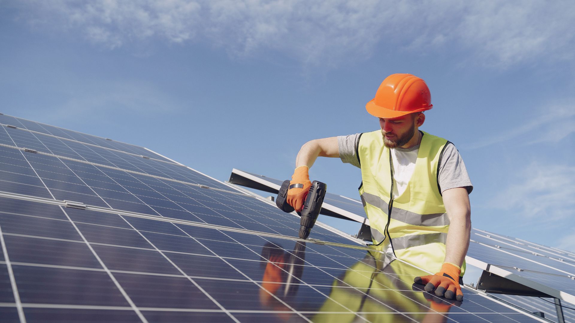 Instalador montando unas placas solares sobre un tejado